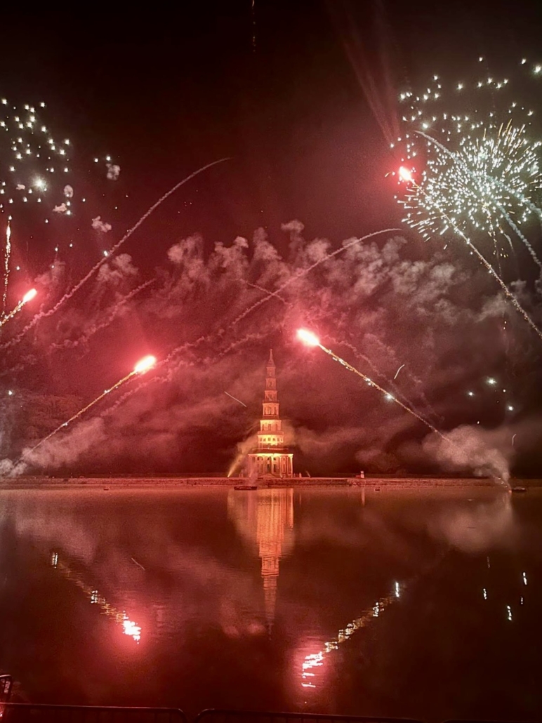 The Pagoda of Chanteloup lit up in red during the Amboise fireworks, reflections on the water